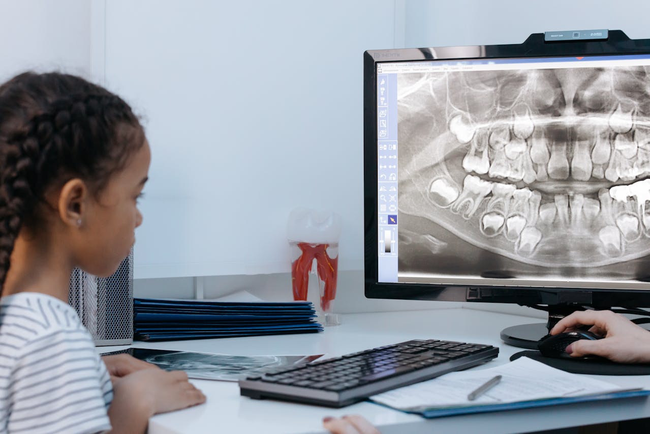 En esta imagen, podemos ver a una niña frente a una radiografía bucodental